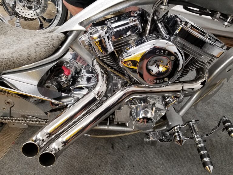 Closeup of chrome S&S V-twin engine and dual pipes on silver custom chopper