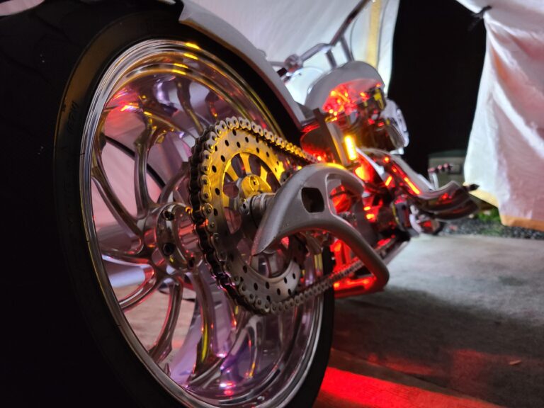 Chrome rear wheel, chain and polished rear sprocket detail on custom chopper